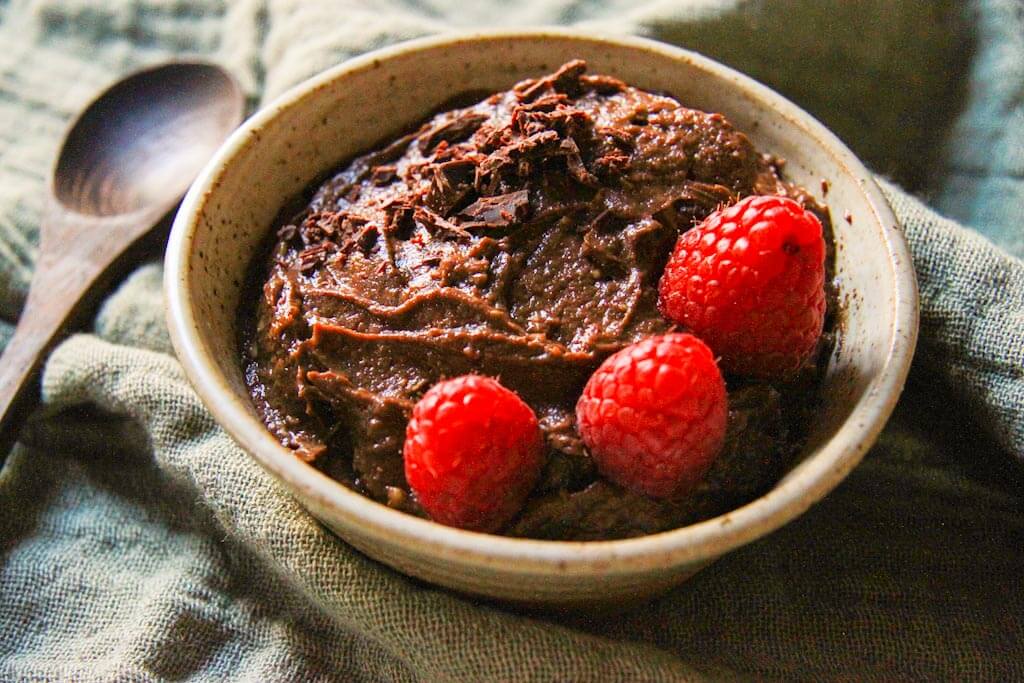 Mousse vegana de chocolate y aguacate con frambuesas.