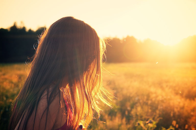 Chica absorbiendo los últimos rayos de sol del día.